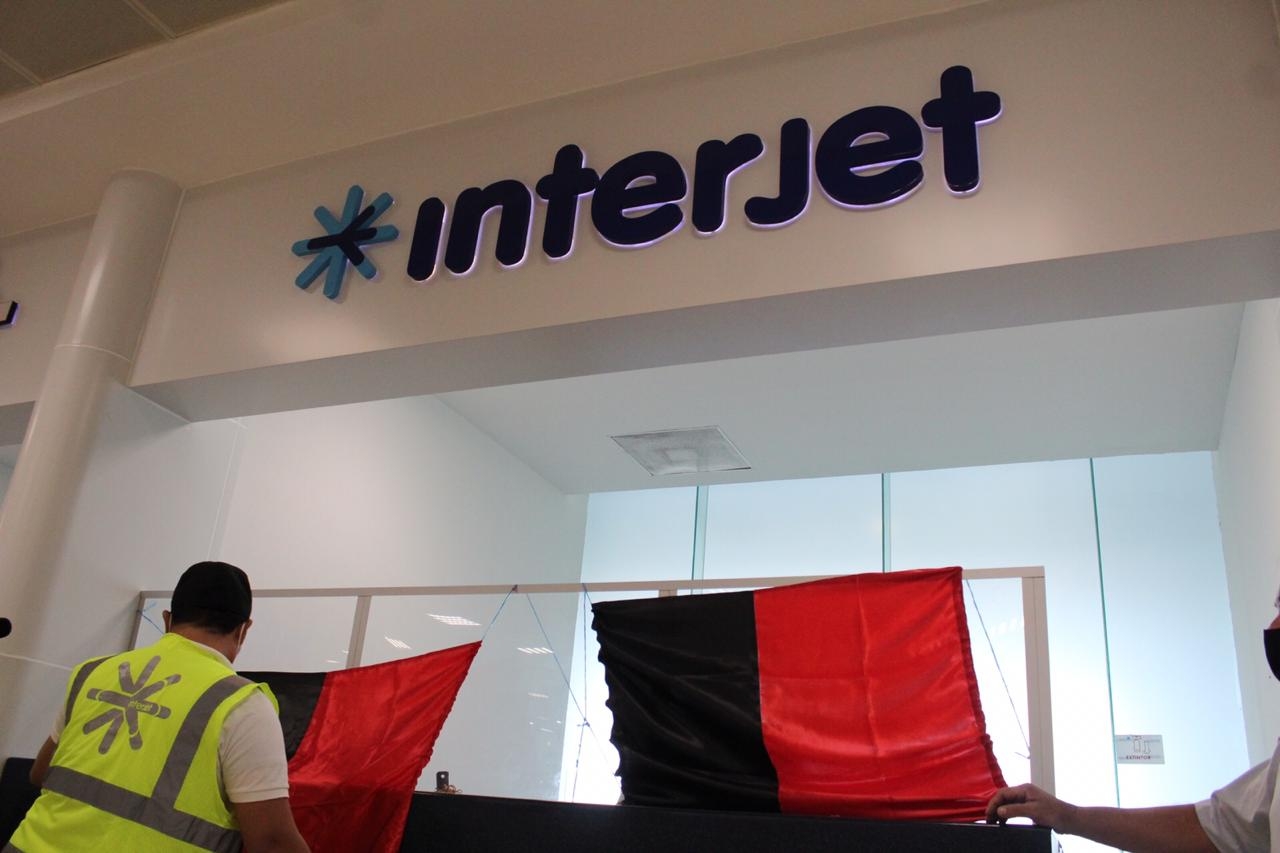 Empleados de la aerolínea Interjet colocan en estos momentos las banderas rojinegras para anunciar el inicio de la huelga