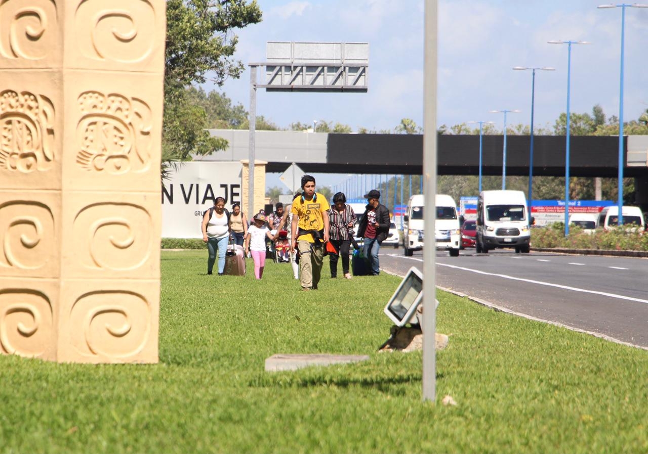 Turistas caminan desde el aeropuerto de Cancún para ir al Mercado 23