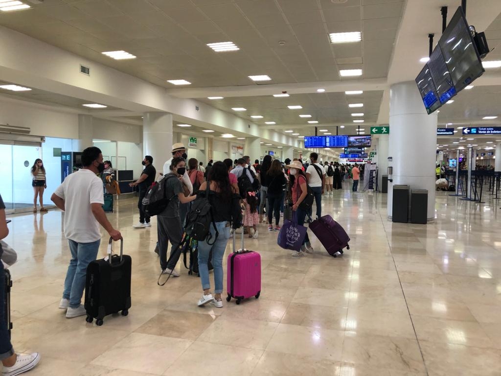 Largas filas retrasan actividades de viajeros en el aeropuerto de Cancún