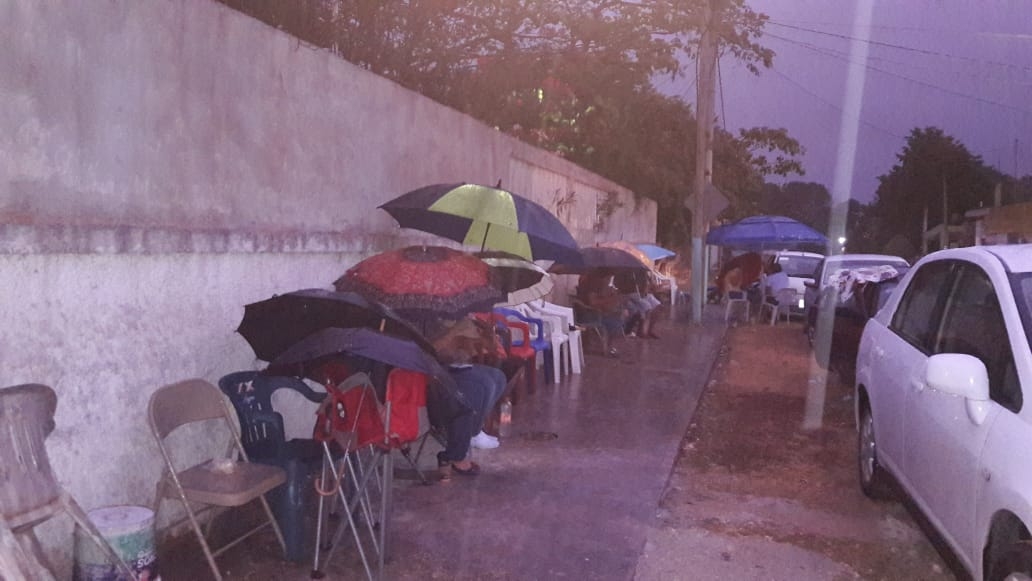Adultos mayores hacen fila bajo lluvia para recibir vacuna en Chetumal