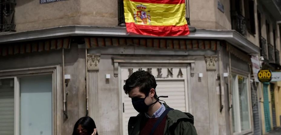 Personas con cubrebocas caminan por las calles de España