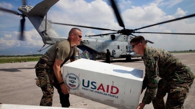 Soldados estadounidenses trasladan un paquete de la USAID