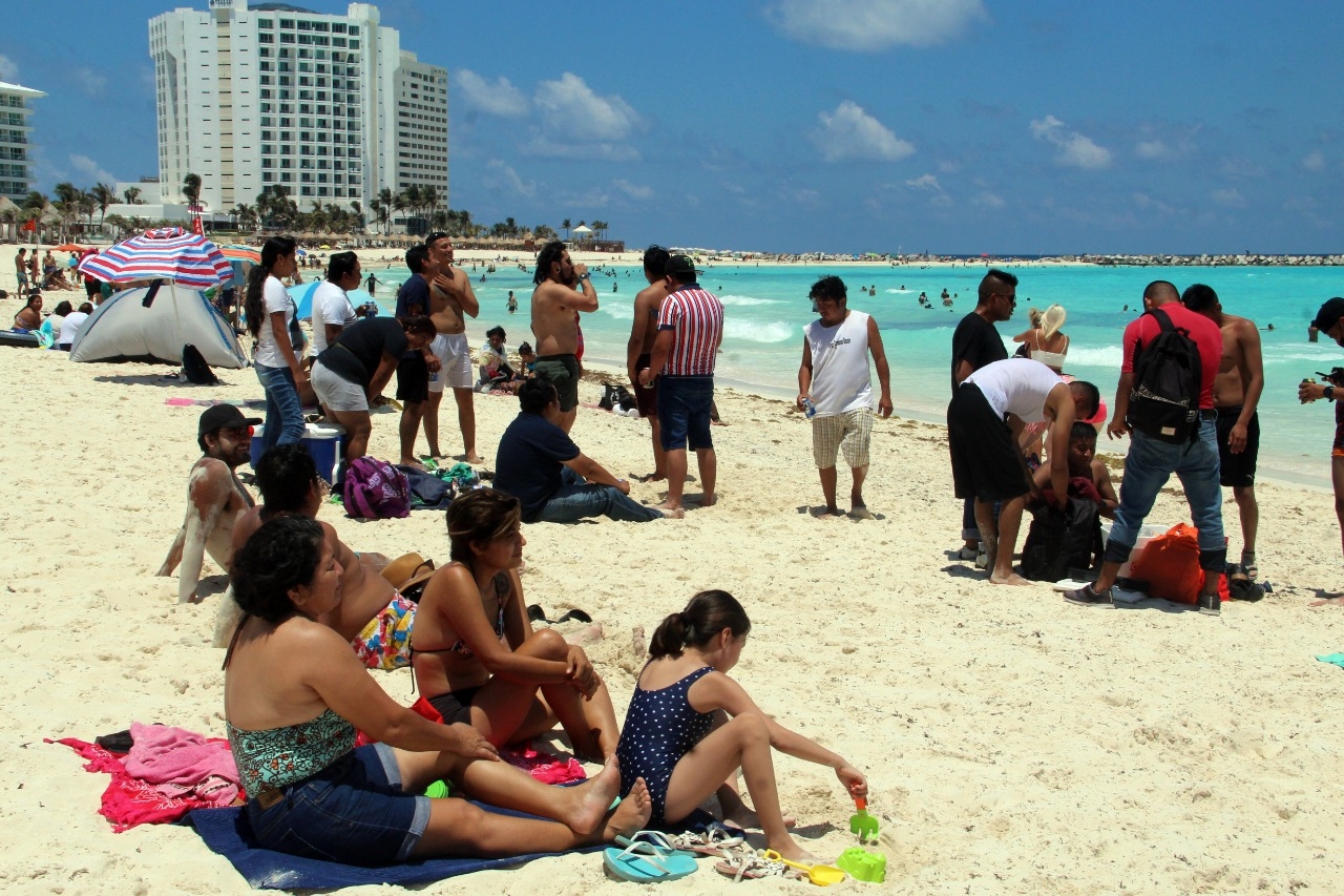 Semáforo Naranja no impide a turistas abarrotar Playa Forum en Cancún
