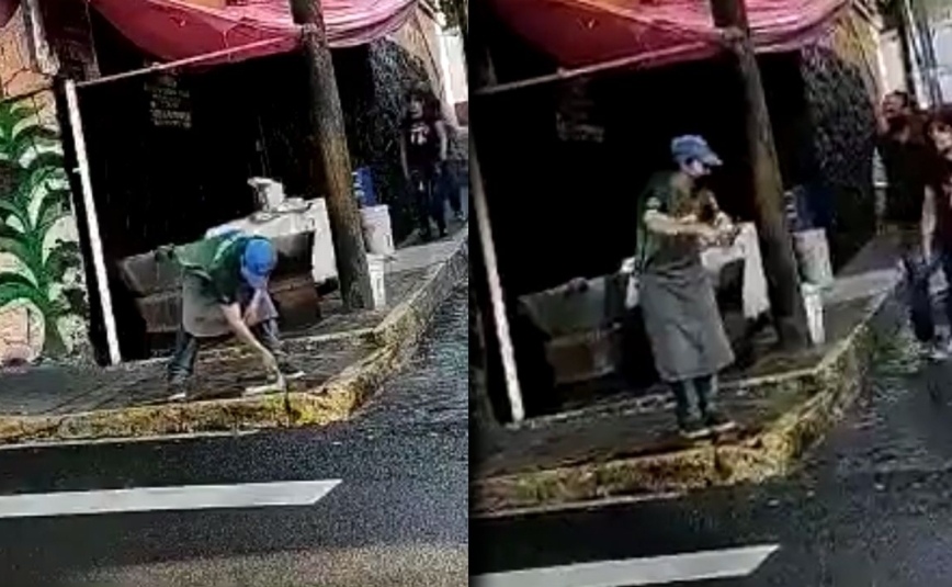 Imagen del trabajador lavando el trapo en la calle