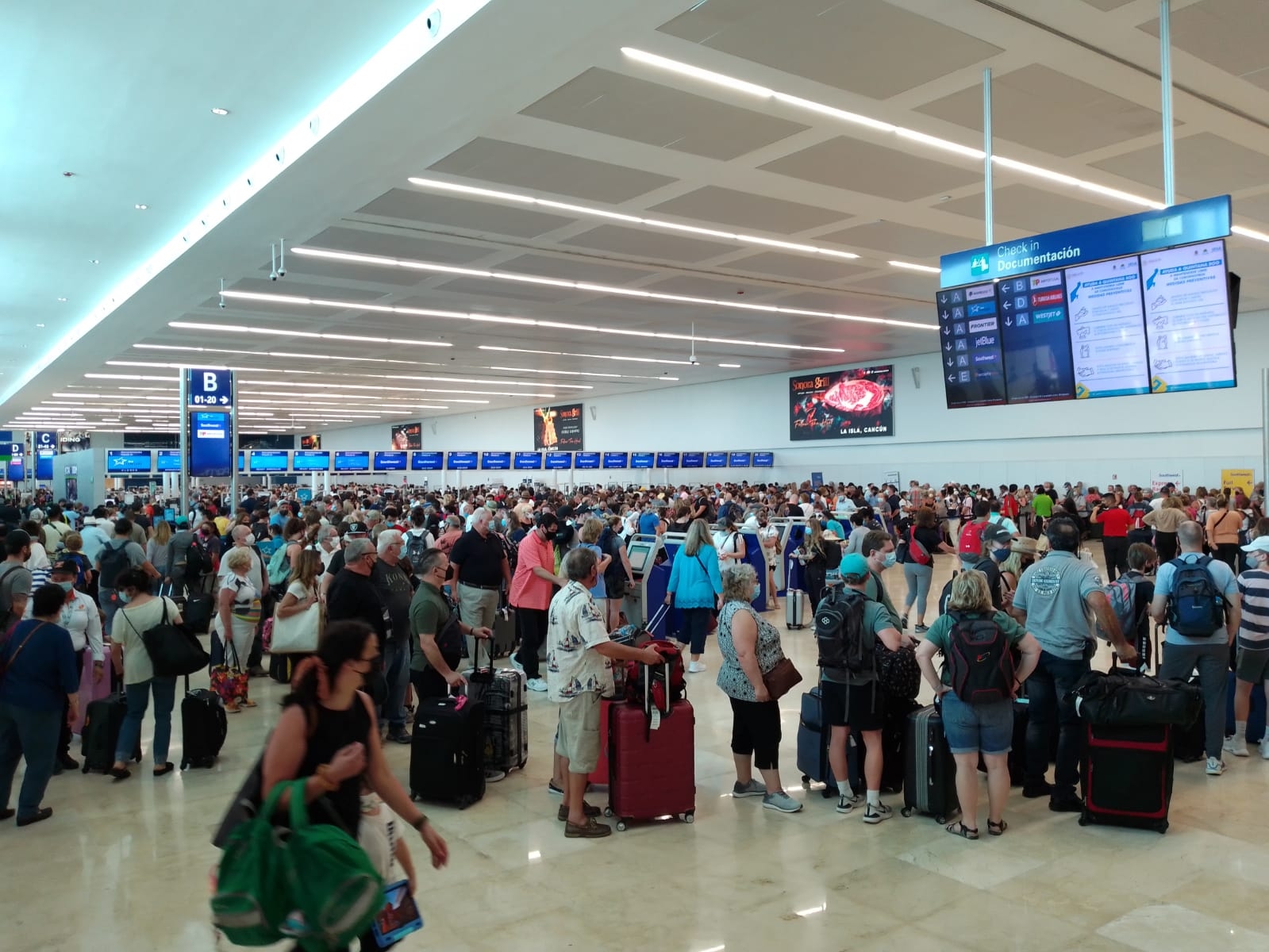 Los pasajeros hicieron largas filas para documentar su equipaje en el Aeropuerto Internacional de Cancún