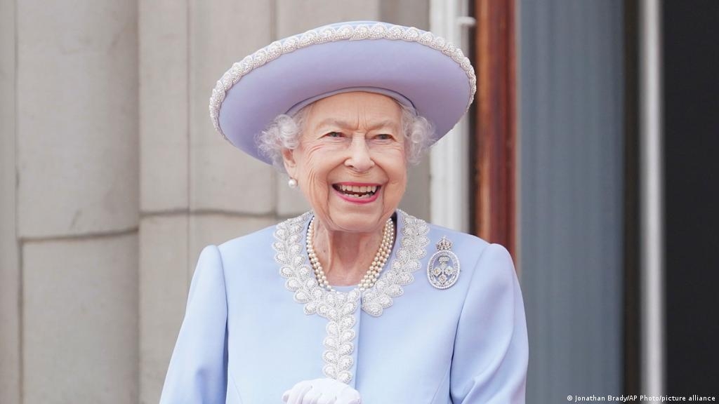 Vestida con abrigo y sombrero azul, la monarca se mantuvo sonriente y de pie pero apoyándose en un bastón