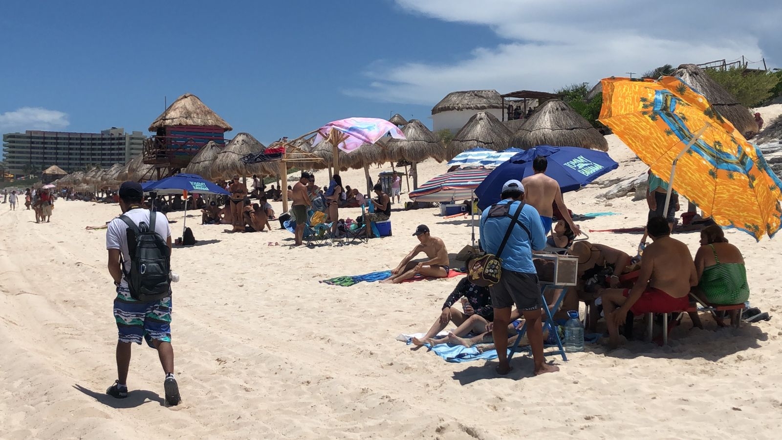 Con sombreros y sombrillas, bañistas disfrutan de un domingo familiar en Playa Delfines