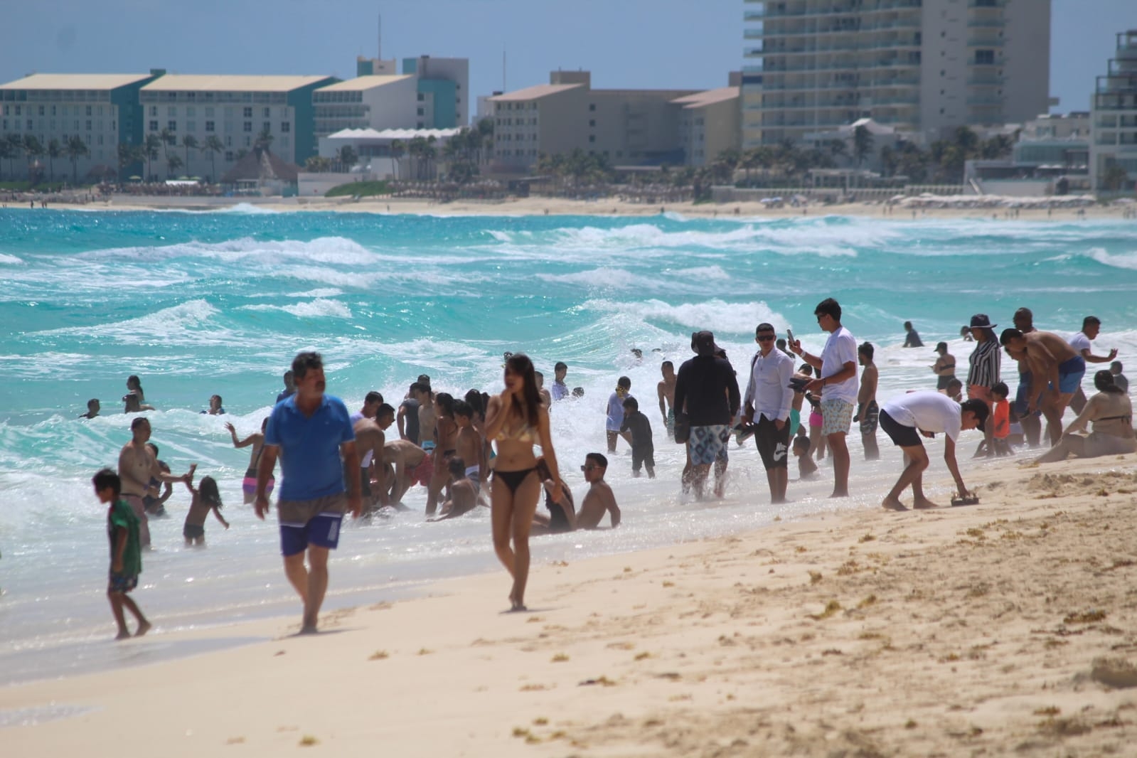 Los visitantes hacen largas colas para tomarse fotos en las letras de Cancún en Playa Delfines