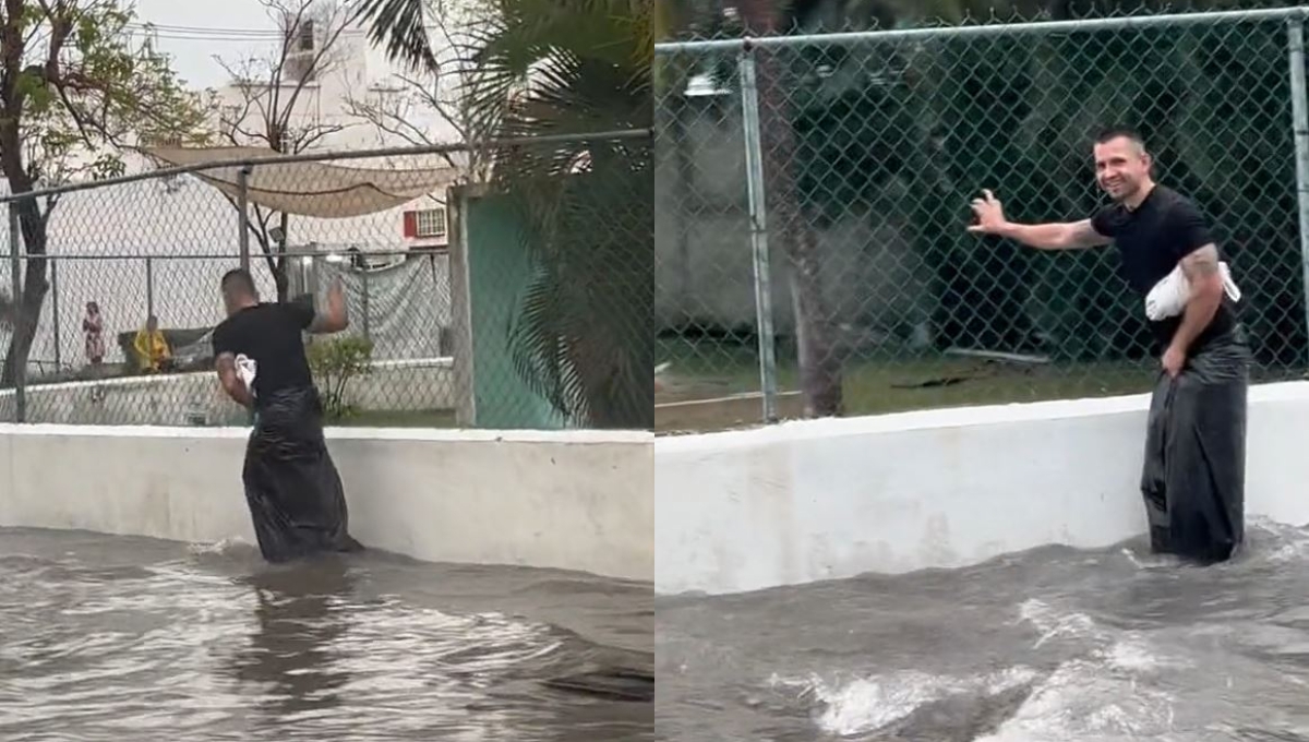 Hombre usa una bolsa de basura para cruzar una calle inundada en Cancún: VIDEO