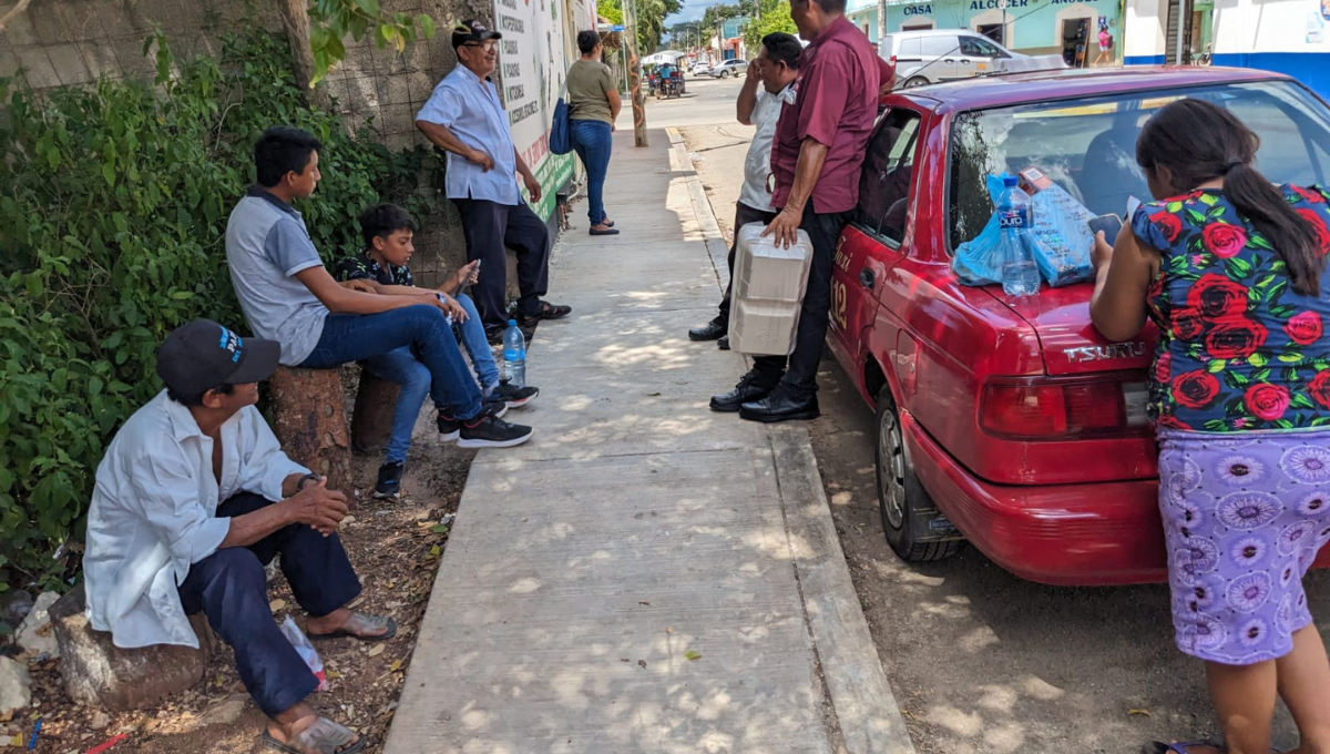 Sin paraderos en José María Morelos, vecinos esperan taxi sentados en piedras