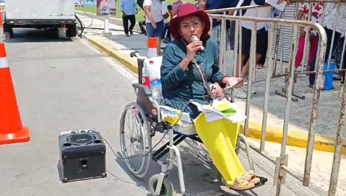 Quinto Informe de AMLO en Campeche: En silla de ruedas, mujer entretiene a simpatizantes del Presidente
