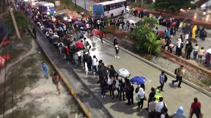 Lluvia causa caos en Cancún; trabajadores hacen largas filas para subir a un camión